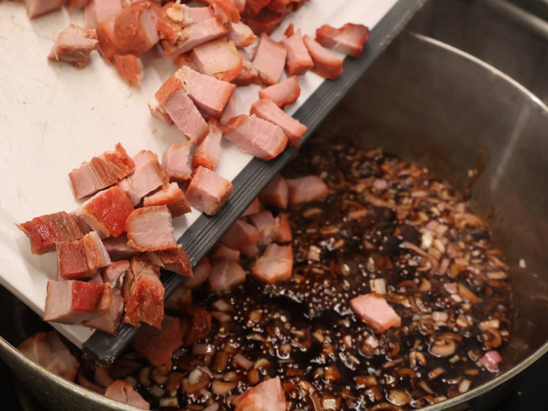 Diced char siu pork added to a pan of shallots and sauce