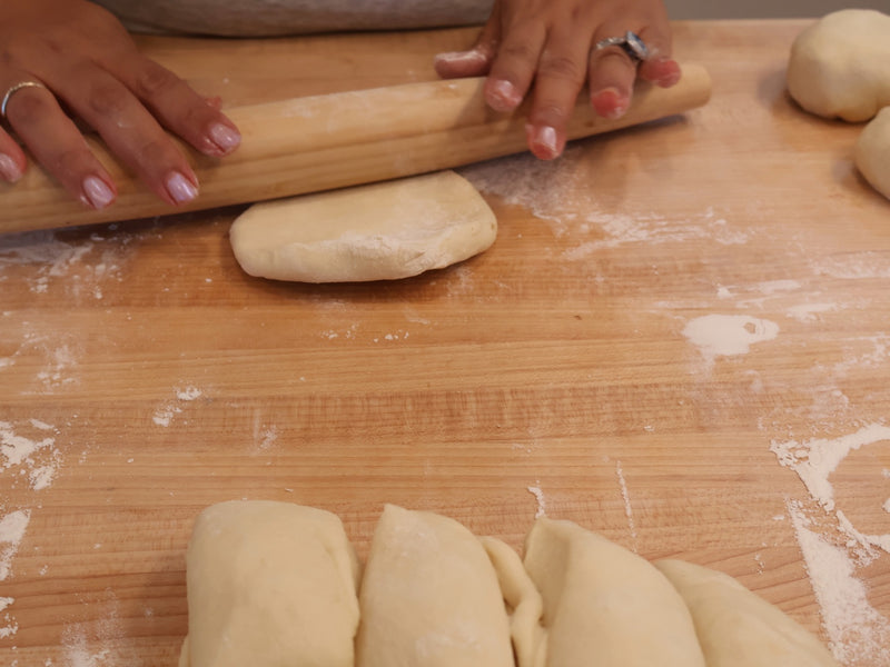 Shaped buns sealed seam-side down on a lined sheet pan