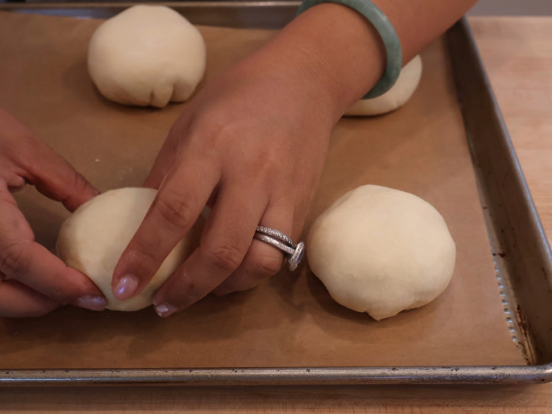 Buns brushed with egg wash before the bake