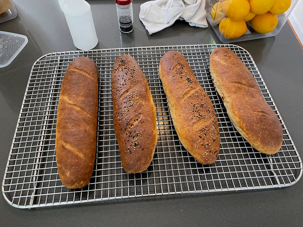 Fresh baguettes cooling on a wire rack