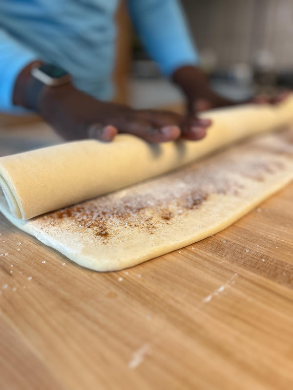 Rolling the filled sheet into a tight log