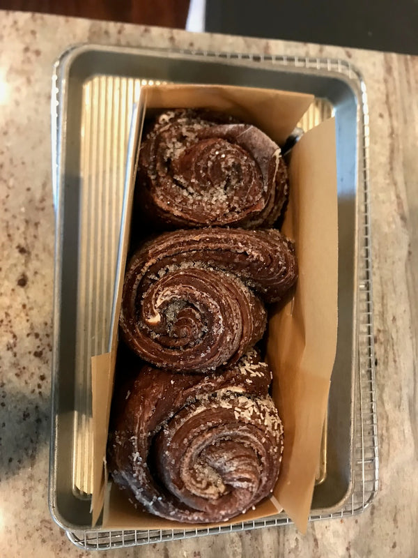 Three swirled rolls set in a parchment-lined pan