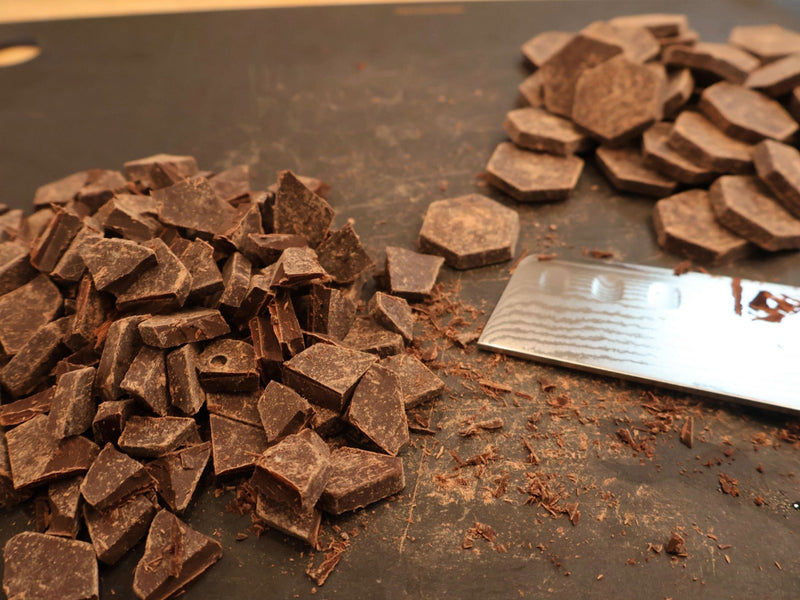 Caramel pieces being chopped with a kitchen knife for fall bark