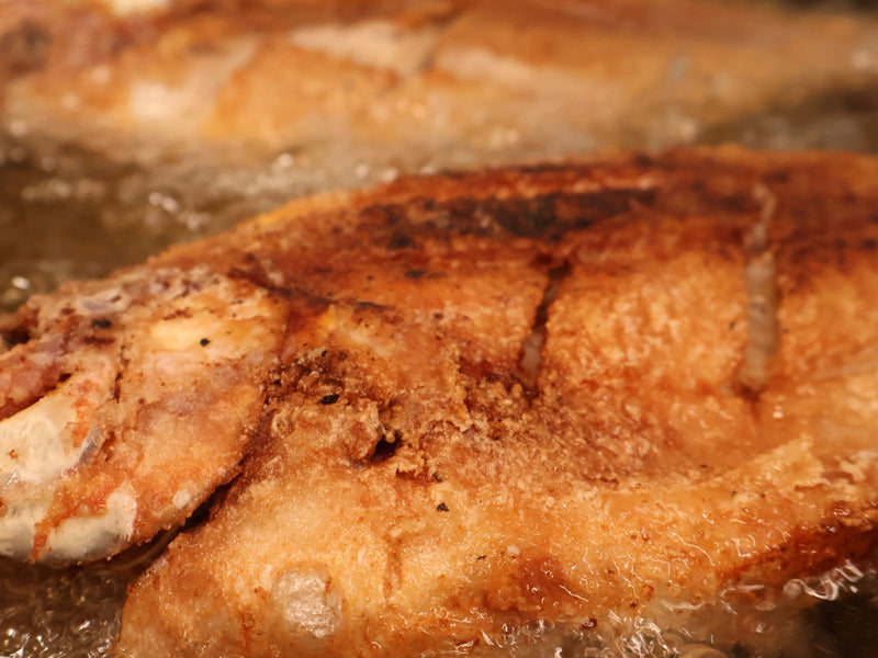 Seasoned raw fish pieces staged next to the fried batch