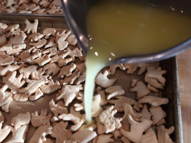 Animal crackers being coated before baking