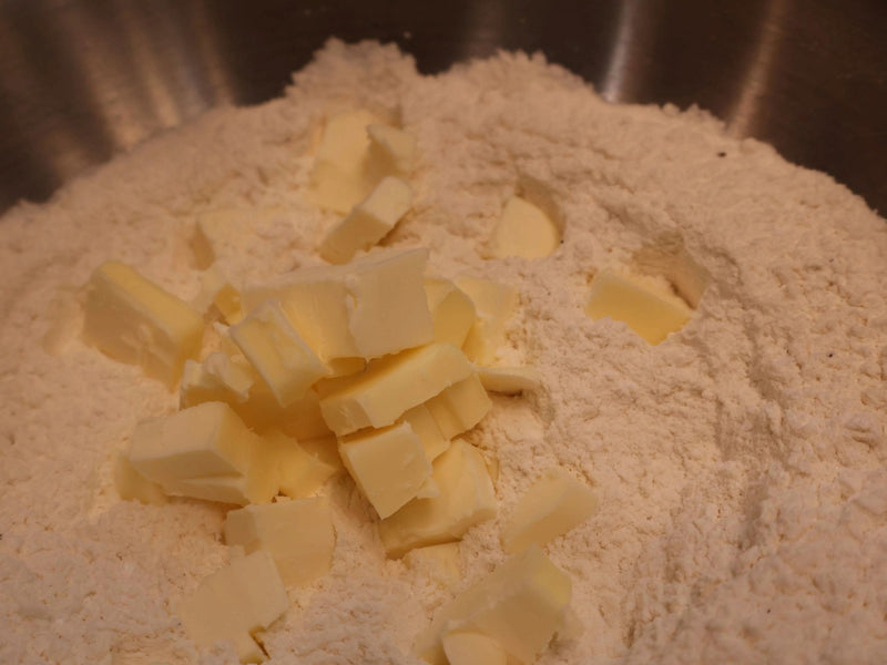 Cold butter being worked into biscuit dough