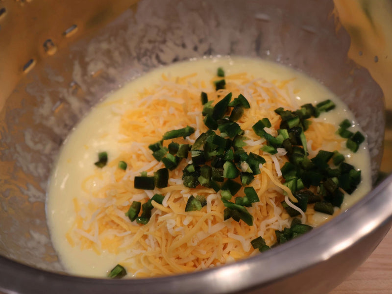 Cheddar and jalapeño being mixed into biscuit dough