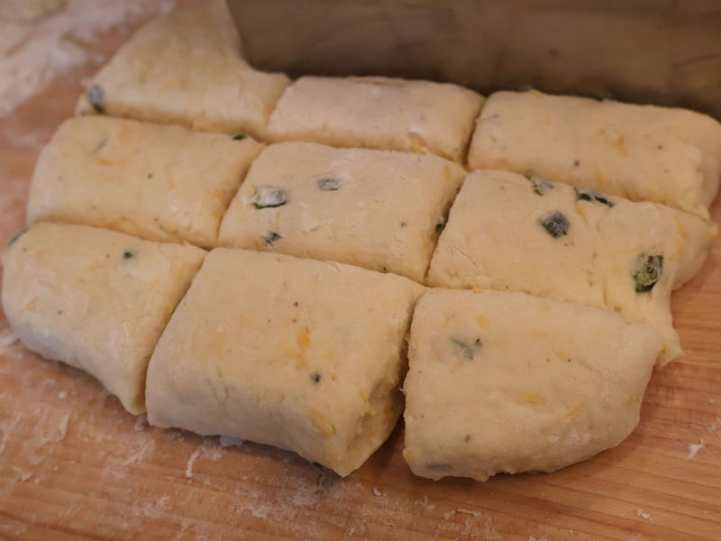 Jalapeño cheddar biscuits cut and arranged before baking