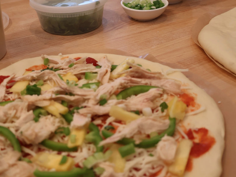 Bowls of pizza toppings set out for guests to choose from