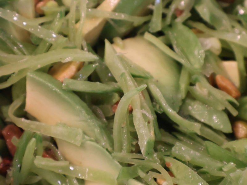 Avocado pieces folded into the snow pea salad