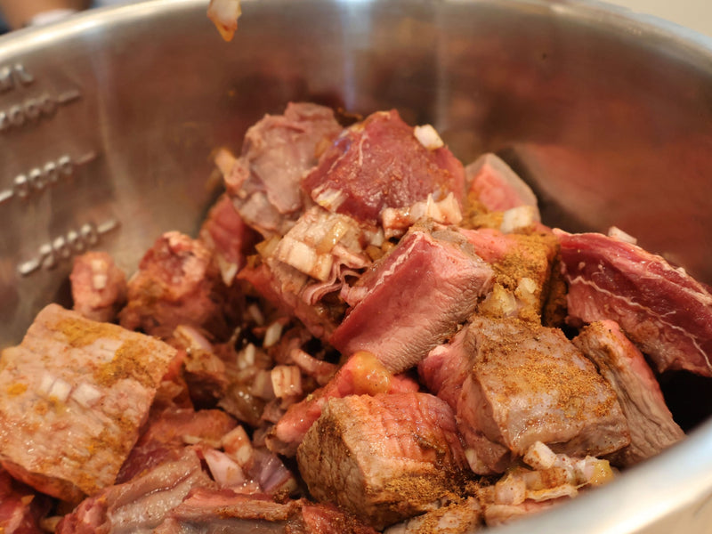 Whole spices and fresh aromatics measured out for a bò kho marinade