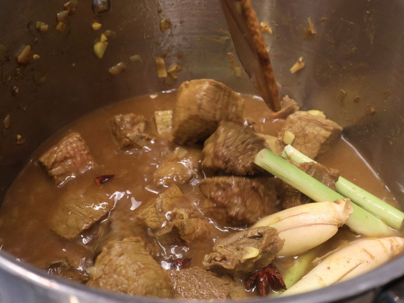 Lemongrass star anise and cinnamon toasted in a pot at the start of the stew