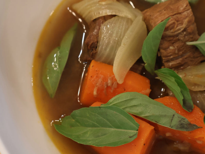 Bò kho served over rice noodles with fresh herbs